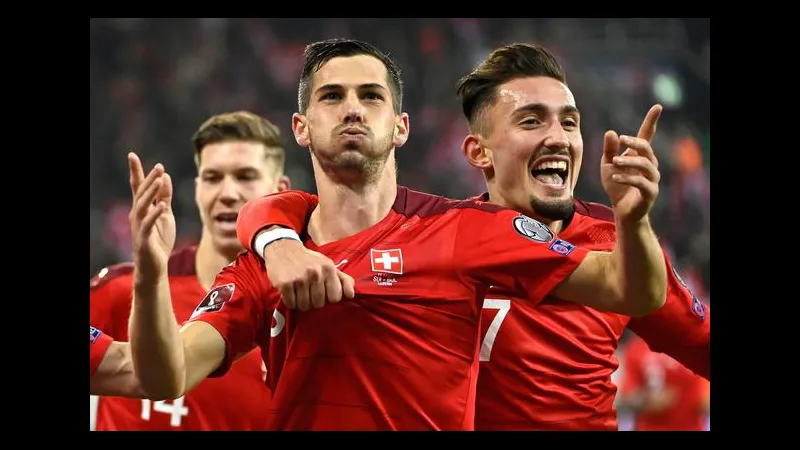 Cầu thủ Thụy Sĩ dẫn bóng trước sự truy đuổi của đối thủ Argentina